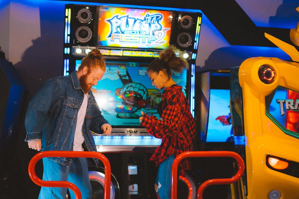 People playing an arcade dancing machine.