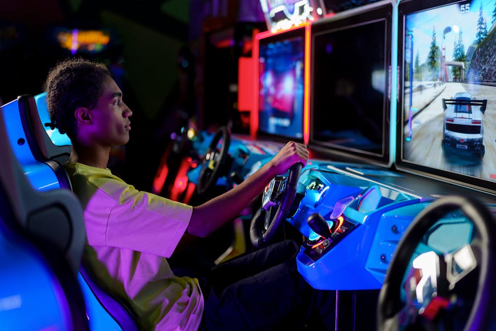 Teenager playing a racing game at an arcade.