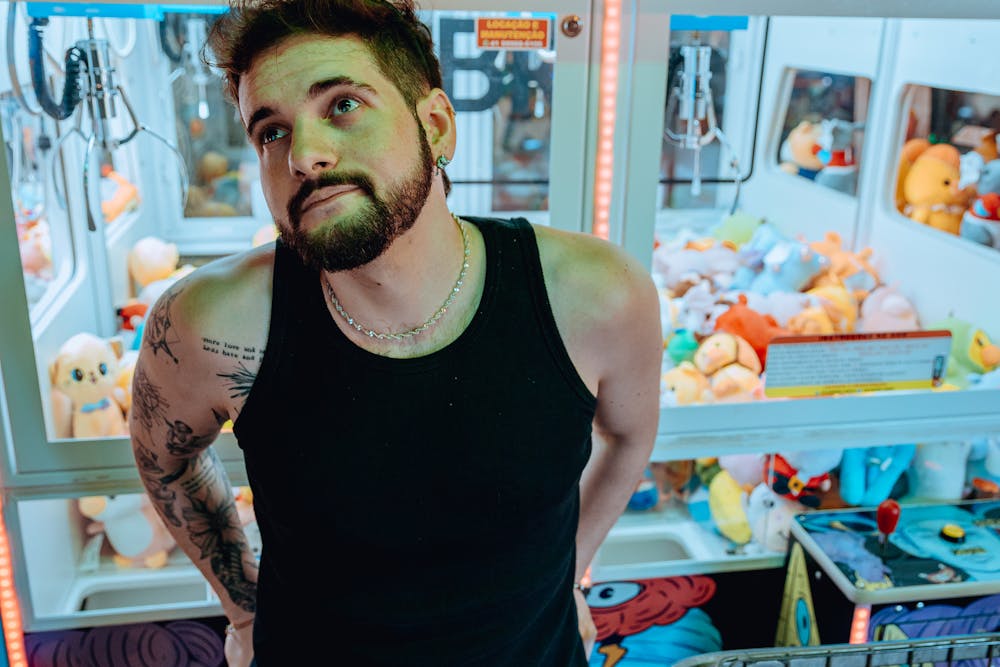 Man eyeing a plush toy claw machine.