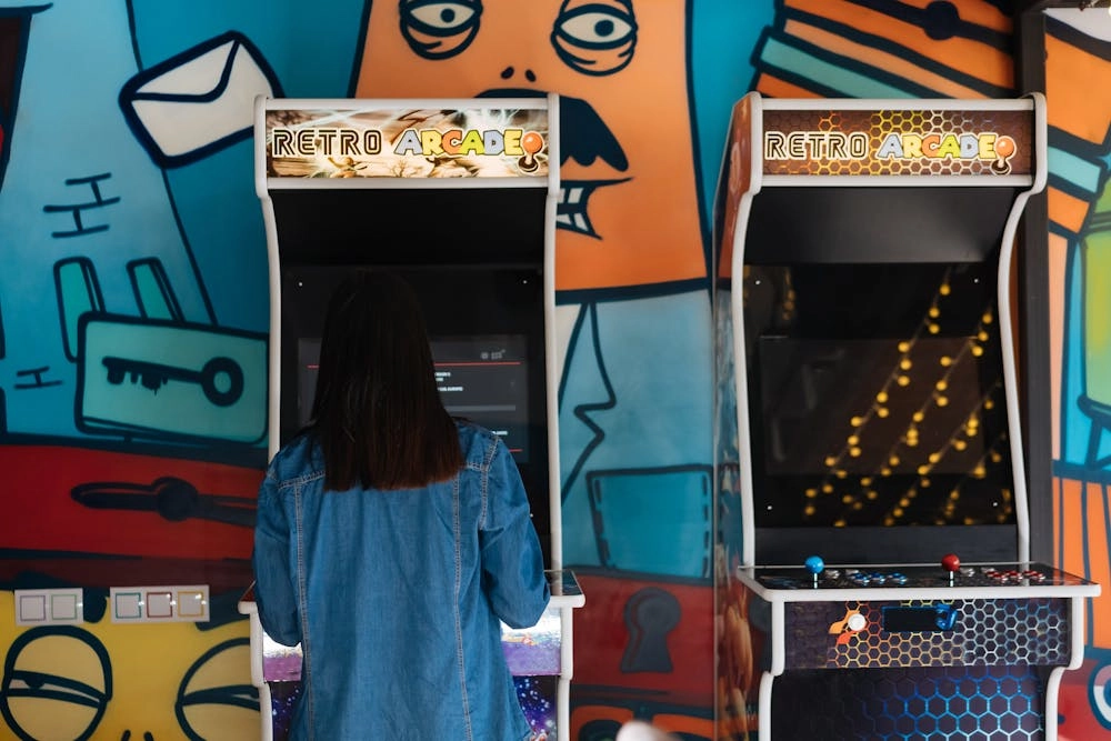 A woman playing a retro arcade game in front of a colorful graffiti wall. - VRN0.1
