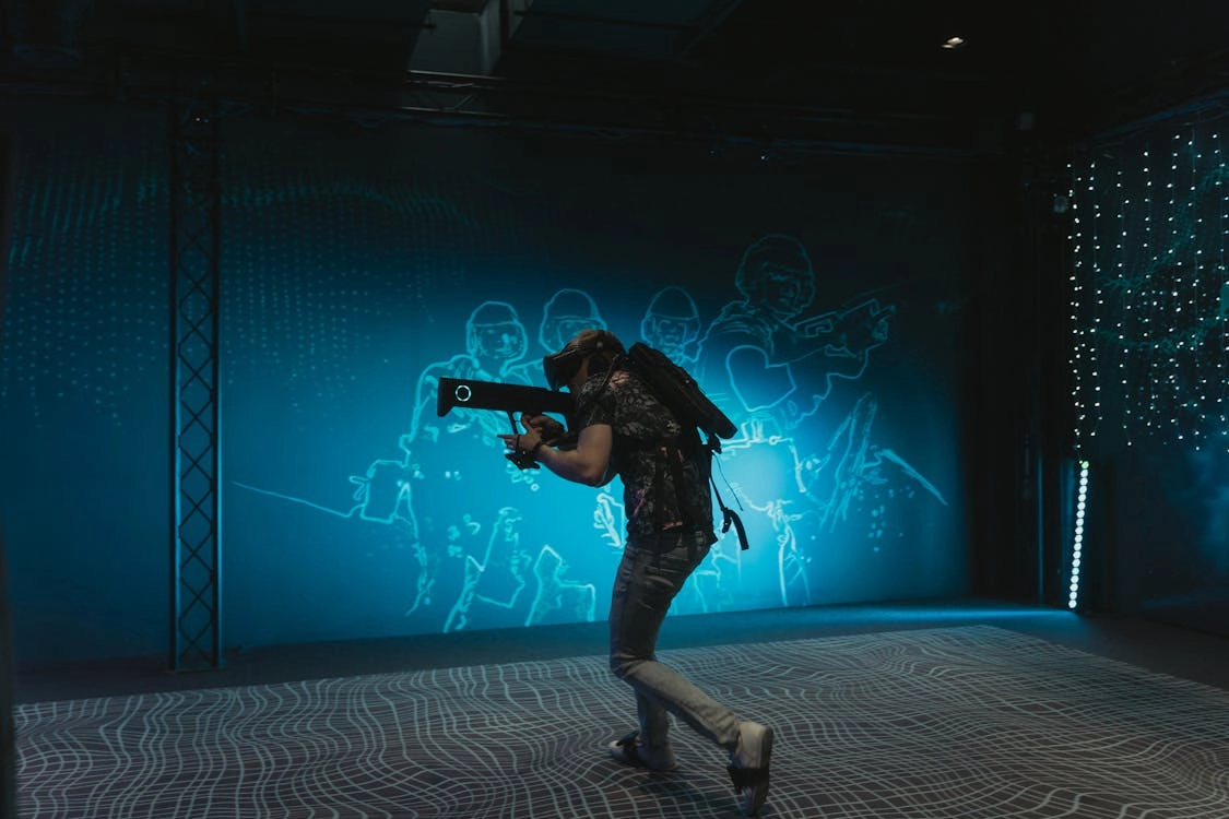 Person playing immersive VR shooter games, wielding a virtual weapon in a futuristic-themed arena. - VRN0.1