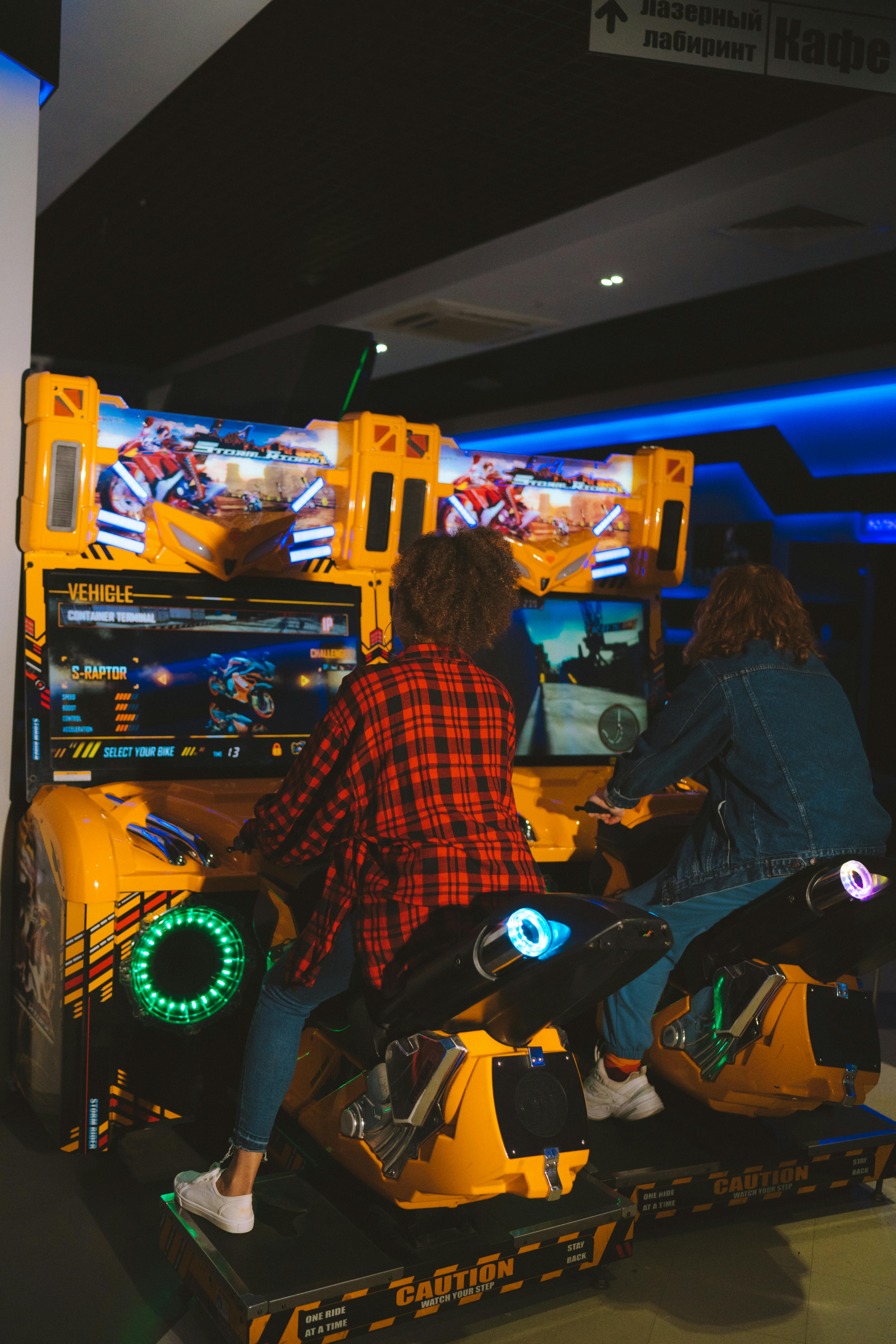 juego de carreras de motos Dos jóvenes jugando a un juego de carreras de motos en un salón recreativo. Ambiente vibrante y divertido.