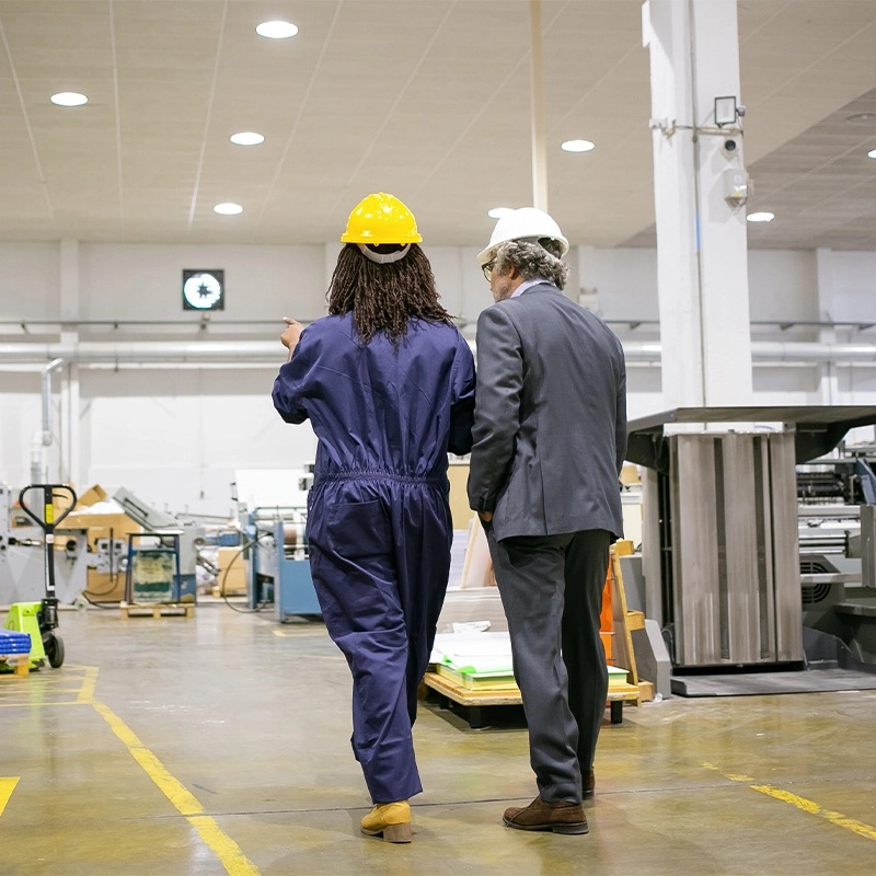 rear-view-boss-standing-factory-listening-plant-worker - Senkelly