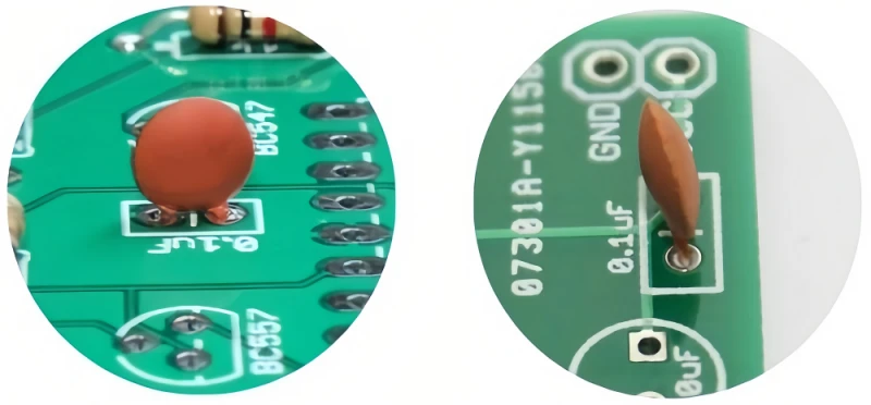 Close-up of a 220nF capacitor application on a green circuit board.