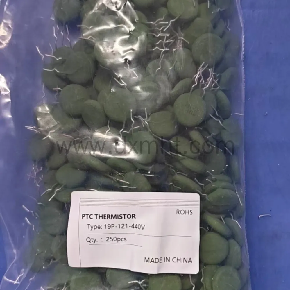 A bag of green disc-shaped PTC Inrush Current Limiter thermistors with a product label. - DXM