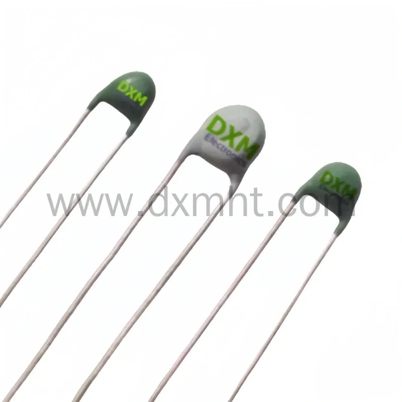 Three DXM electronic components for thermistor ptc vs ntc applications on a white background.