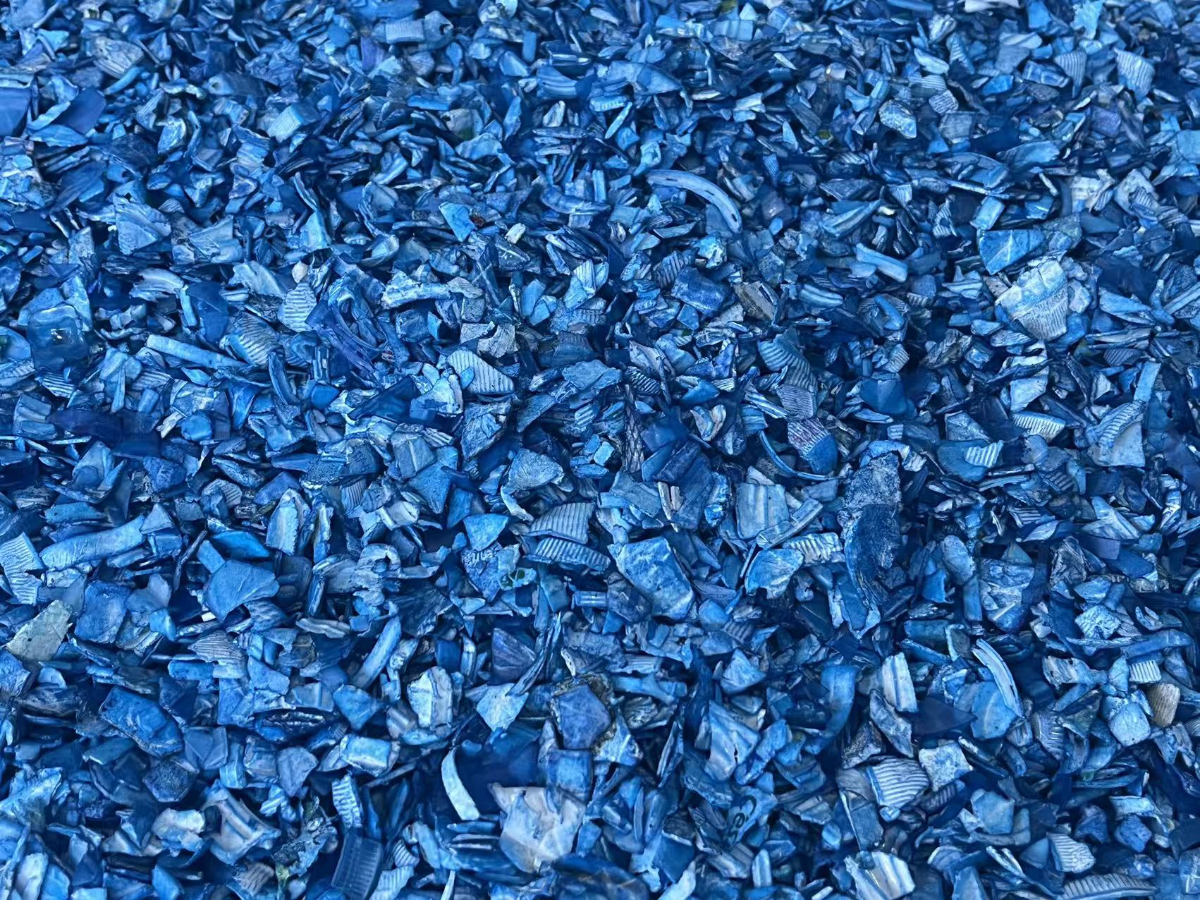 A pile of shredded blue recycled plastic fragments.