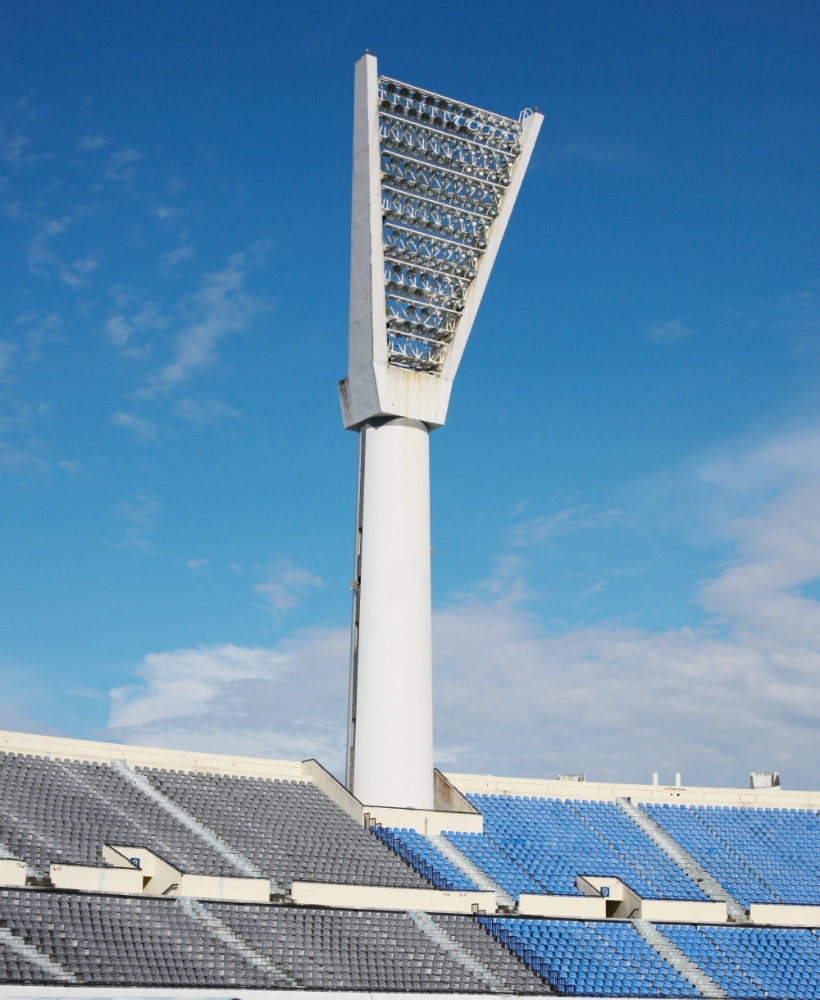 Smart-Solar-Street-Light Lampu Jalan Solar Pintar menerangi tempat duduk stadium di bawah langit biru terang.