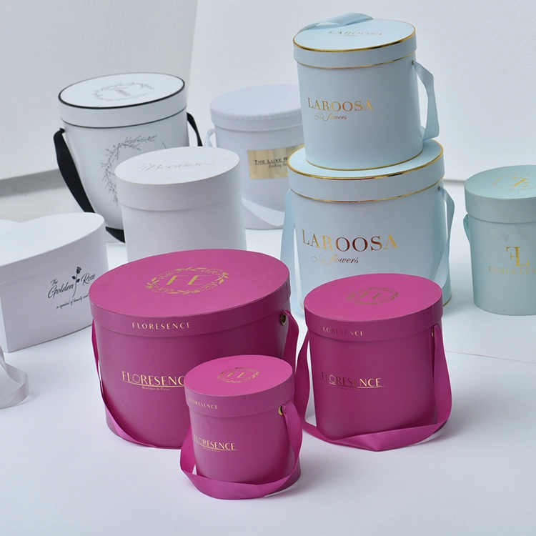 Assorted luxury round gift boxes in pink, blue, and white with gold lettering. - Yifeng Packaging