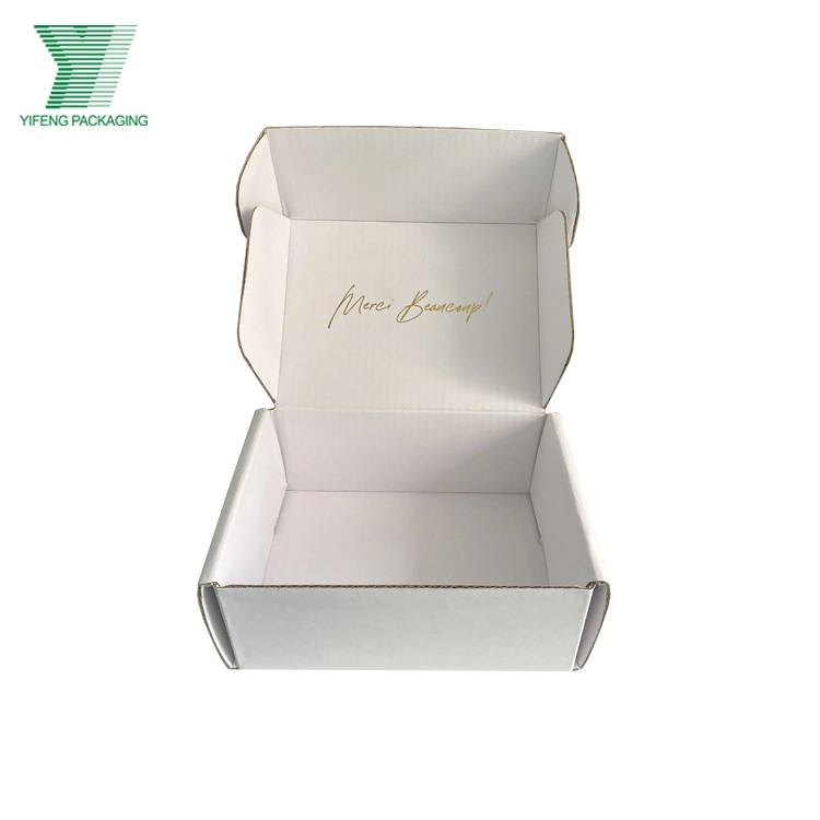 Open white corrugated mailer box with gold "Merci Beaucoup" script inside. - Yifeng Packaging