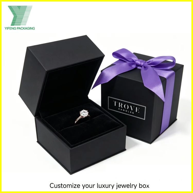 A diamond ring in a custom black luxury jewelry box with a purple ribbon. - Yifeng Packaging