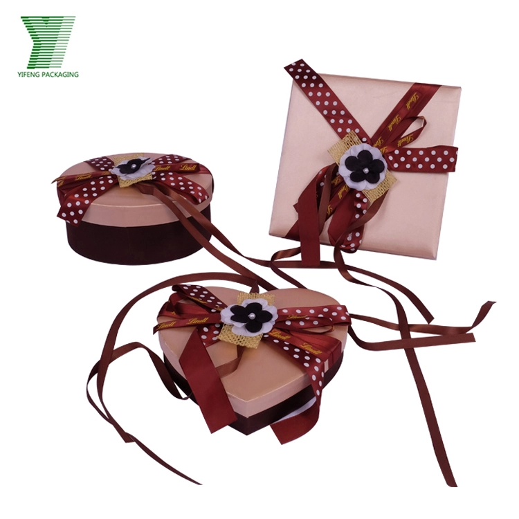 Three decorative gift boxes with polka dot ribbons and floral accents. - Yifeng Packaging