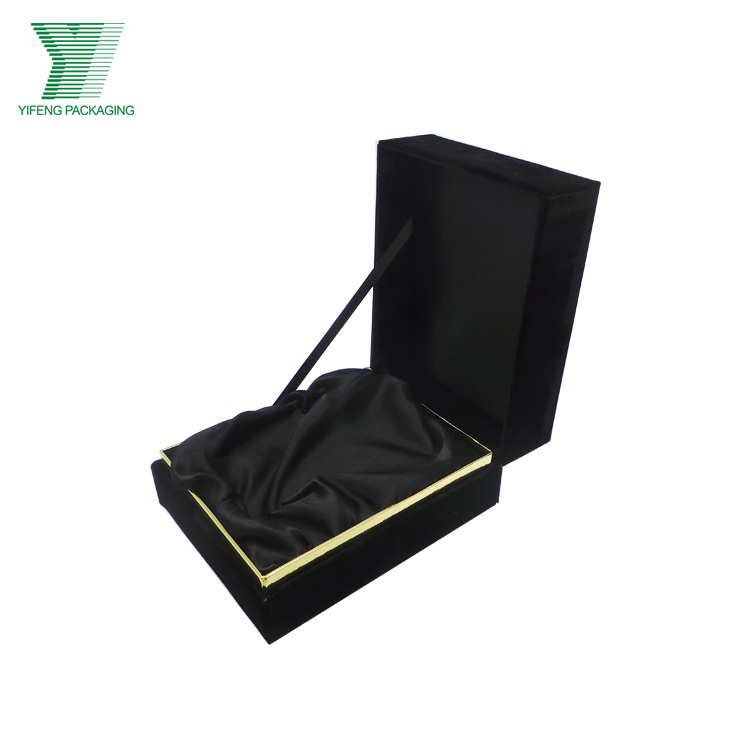 Open black velvet gift box with gold trim and satin lining.